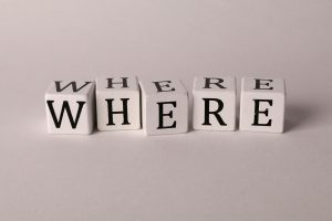 Close-up of white blocks with letters spelling 'WHERE' against a plain background.